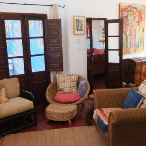 Living room with fireplace, featuring antiques and original art