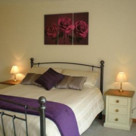 master bedroom with kingsize bed, ensuite shower room & access to the patio