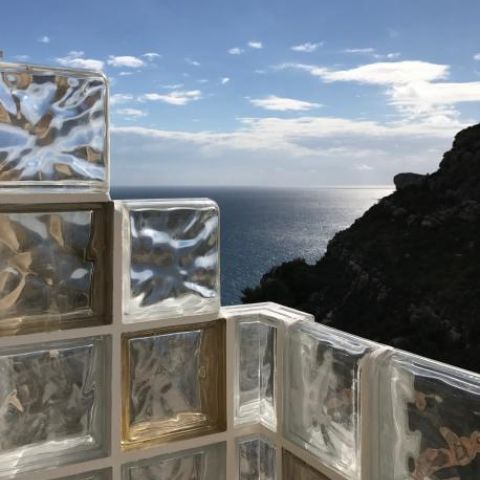 Glamorous glass brick pool shower with a sea view
