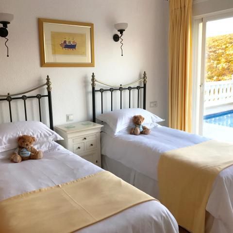 Sunny twin bedroom with glass doors to pool terrace