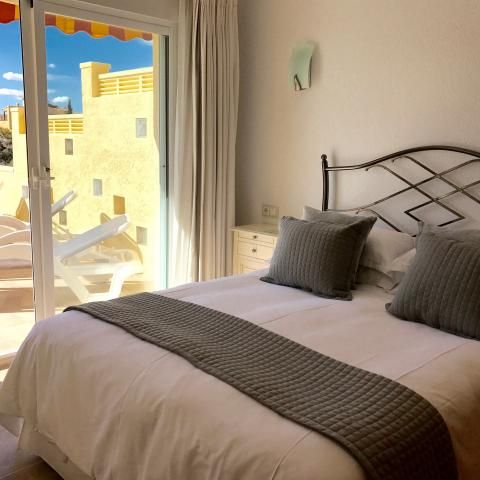 Sunny king-size bedroom with glass doors to pool terrace